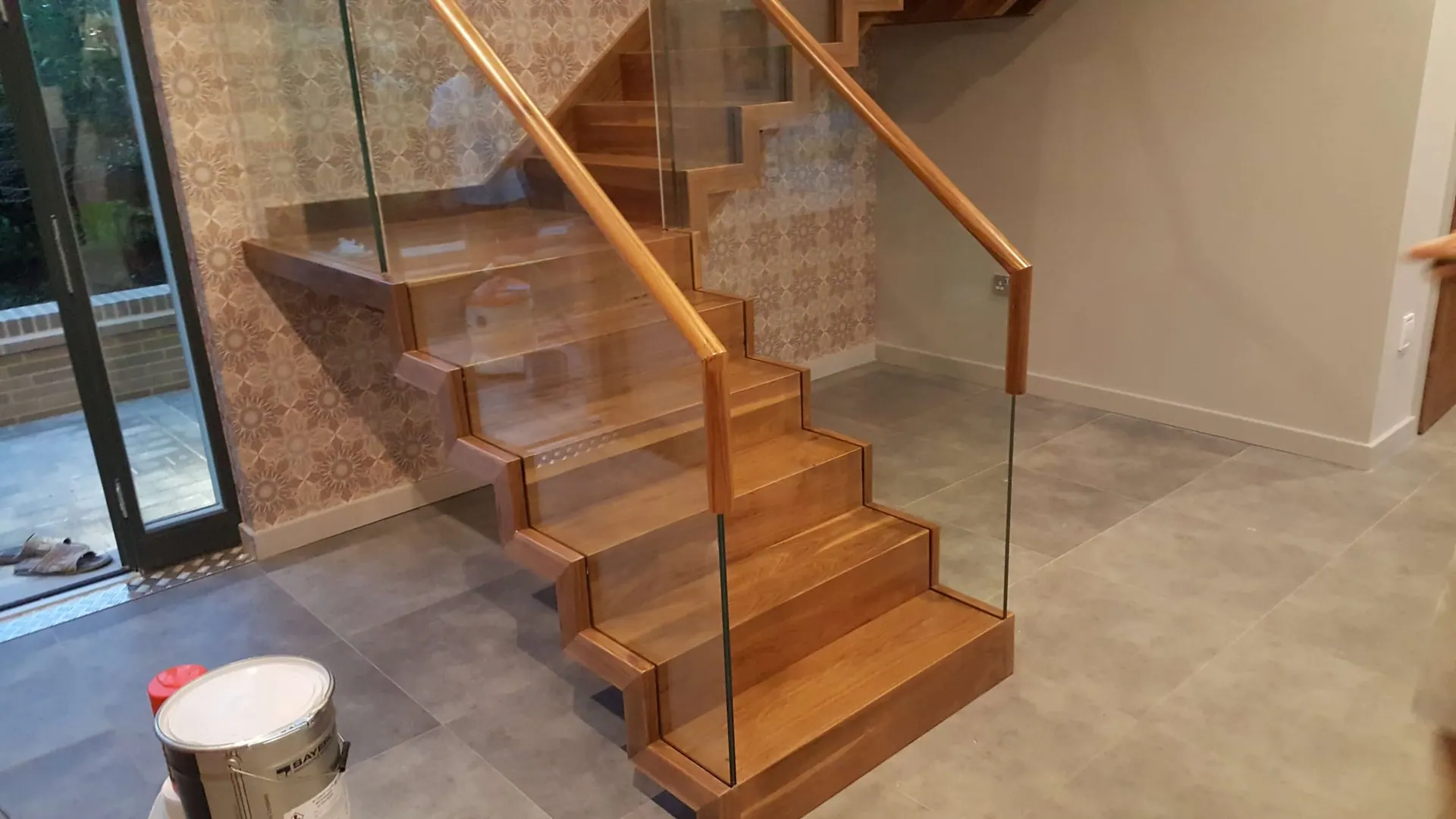 Oak staircase with glass balustrade at the final fitting stage