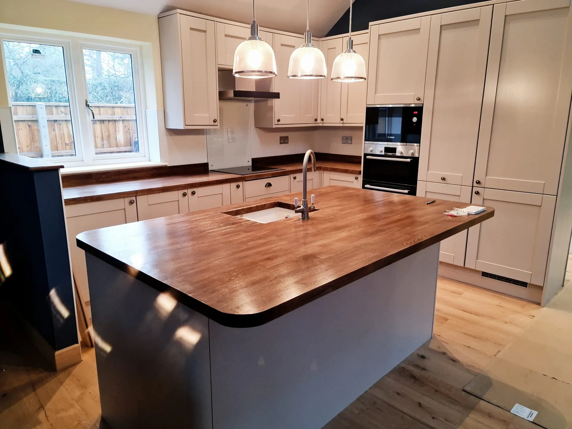 Shaker kitchen with a solid timber island worktop and pendant lights